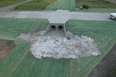 Concrete culvert with twin drainage pipes.