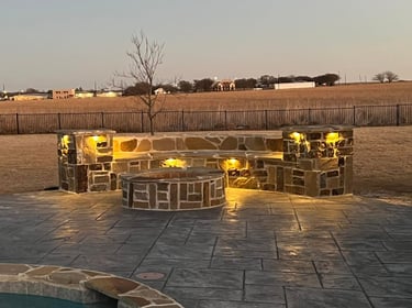 Stone fire pit on a stamped concrete patio.