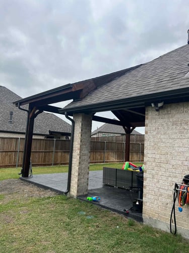 Covered patio extension with dark wood posts.
