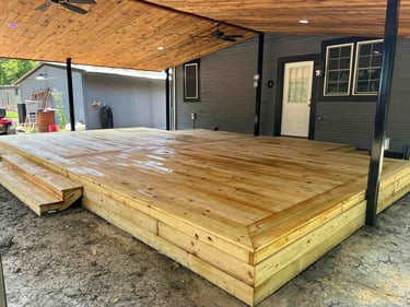 Covered wooden deck with steps and natural wood ceiling.