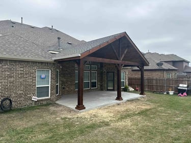 Gable-style covered patio with dark wood posts.