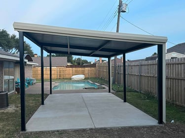 Metal patio cover by a backyard pool.