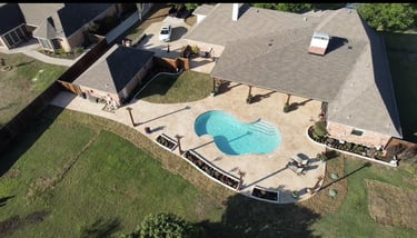 Aerial view of backyard with pool and patio.