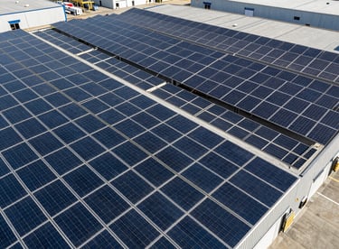 Aerial view of a modern North American shipping warehouse completely covered in energy-efficient solar panels.