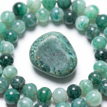 Polished green jasper palm stone centered within a circle of green moss agate crystal beads.