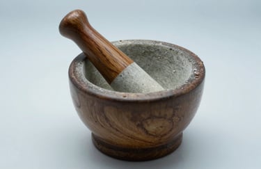 A sharp professional photograph of a pharmaceutical mortar and pestle on a clean white surface with a soft light blue background.