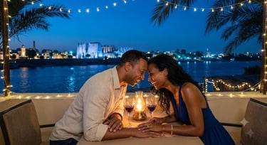 A couple enjoys a romantic dinner on a terrace overlooking the Nile River at night in Egypt.