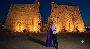 A couple standing in front of the illuminated Luxor Temple at night in Egypt.