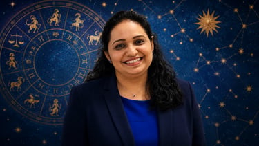 A smiling female professional astrologer in a blue blazer against a zodiac wheel and starry night sky backdrop.