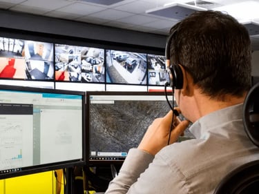 Security professional monitors live surveillance Manchester camera feeds in a central control room.