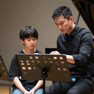 An inspiring scene of a professional musician mentoring a young student during a workshop, both looking at a music stand with steel blue accents.