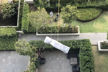 Personal de AVM Mudanzas volando mueble de gran formato en Santa Fe de la Ciudad de México.