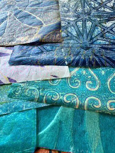 hand-painted collage papers layered in teal and blue with metallic patterns