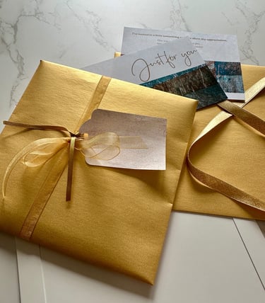gift wrapped package with gold paper and handmade collage paper tag