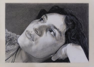 Retrato realista a carboncillo de mujer recostada con mirada hacia arriba, escala de grises