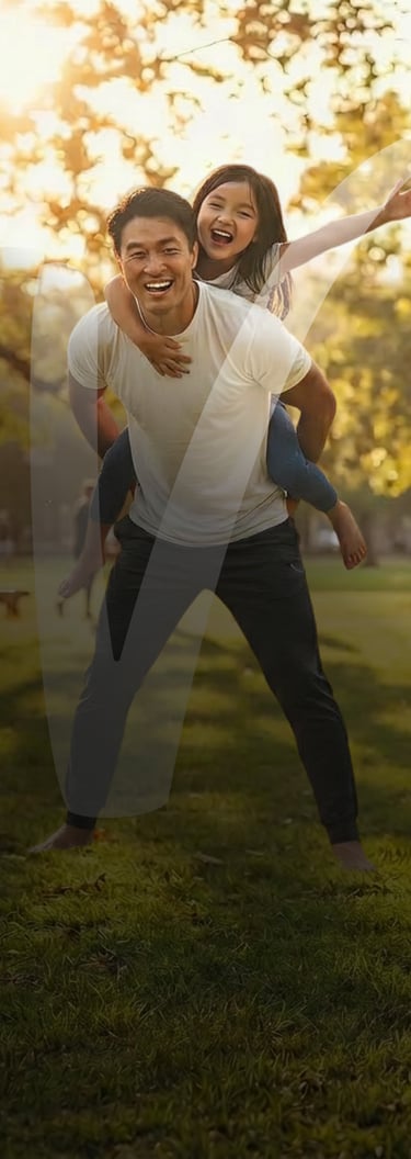 Happy father giving his young daughter a piggyback ride in a sunny park at sunset.