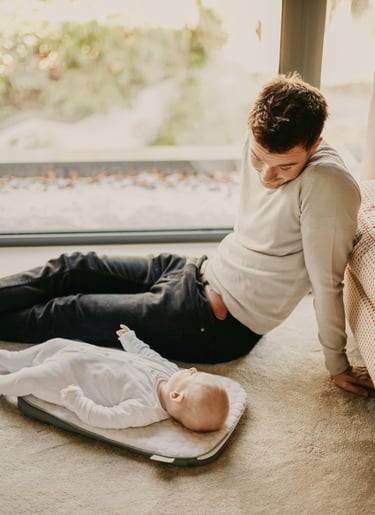 father changing diaper night nursery"