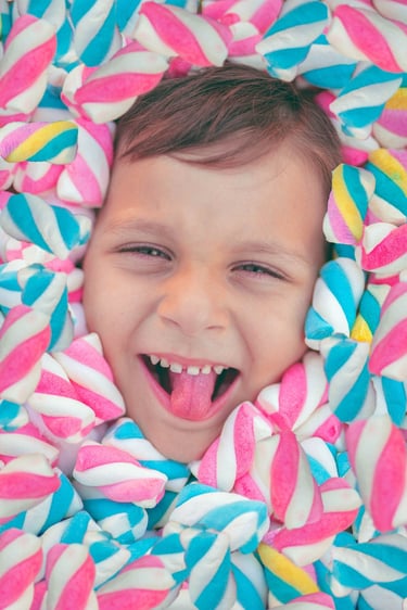 NIÑO SONRIENTE ENTRE BOMBONES
