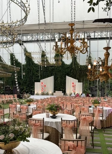 Luxury garden wedding décor with elegant chandeliers, lush greenery backdrop, pastel seating arrange