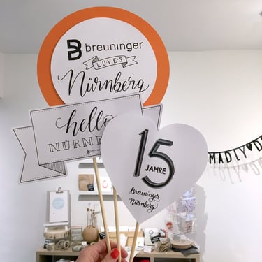 Custom Breuninger Nürnberg anniversary signs on wooden sticks for 15 jahre event celebration.