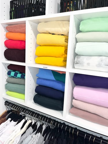 Neatly folded clothing arranged in a master closet as part of a home organizing refresh service