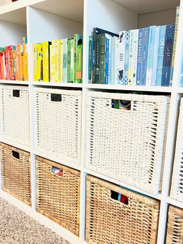 Playroom organization with labeled bins and color coded bookshelf for easy storage