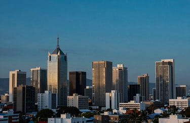 A wide-angle landscape shot of a modern South African urban skyline at dusk, with communication towers subtly visible against a deep blue and teal sky.