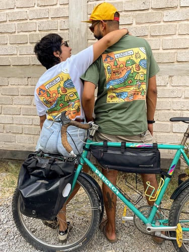 Pareja de ciclistas usando playera ilustrada de un recorrido turístico en bicicleta.