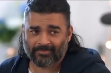 Portrait of actor R. Madhavan with a salt and pepper beard and long hair tied back.
