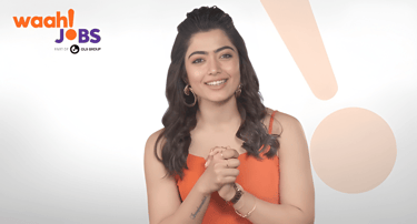 Rashmika Mandanna smiling in a Waah Jobs advertisement featuring an orange dress and job search branding.