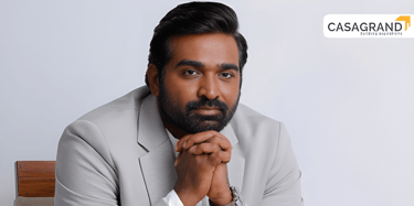 Actor Vijay Sethupathi in a formal grey suit for a Casagrand real estate brand advertisement.