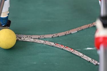 metal chains on a green talble with a yellow ball and miniature soccer players.