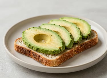 Slices of fresh avocado on whole-grain toast served on an elegant beige #F8F5EF ceramic plate.