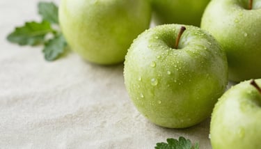 A flat lay of a wellness journal and a dish of fresh berries next to a soft pink #E4C8CB flower.