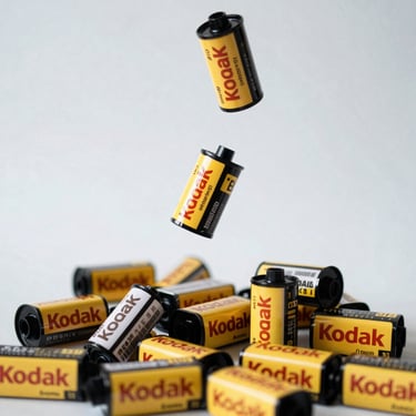 Photo of colorful 35mm film strips laid out on a dark surface with developing equipment.