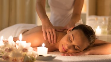 Una mujer relajada recibe un masaje de espalda en un ambiente de spa
