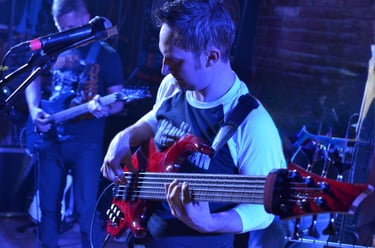 A lively band performing on stage with vibrant lighting in a night setting.