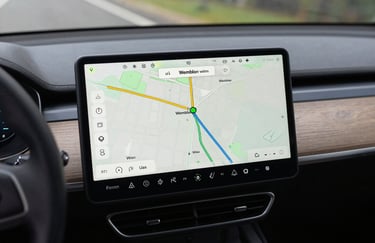 Close up of a modern car dashboard featuring a digital navigation map showing a route through Wembley. Clean, professional photography, European / British interface design, focused and efficient lighting.