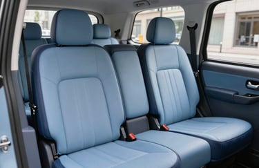 Interior of a clean, modern taxi featuring soft blue upholstery and dark navy trim in a British / UK vehicle, bright and inviting.