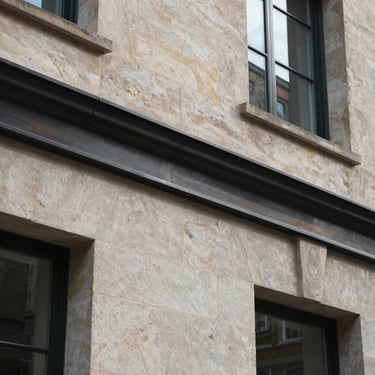Close-up detail of high-quality stone masonry and metal finishings on a contemporary British building, highlighting professional craftsmanship.