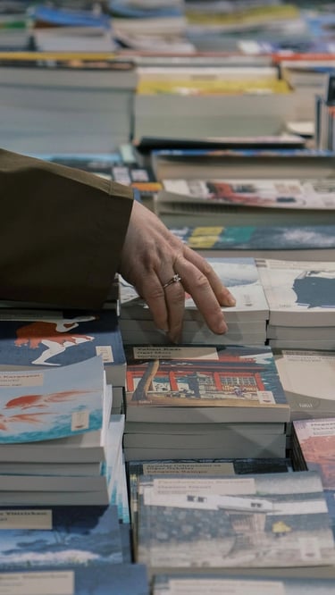 Une main qui choisit un livre dans une librairie - formation La Fabrique - Fanny Campan, Plumes et Voix.