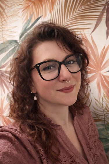 Émilie, sonothérapeute certifiée, souriante, debout dans son cabinet avec  diapasons thérapeutiques