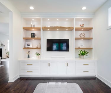 Custom built-in wall unit and shelving with installed lighting.