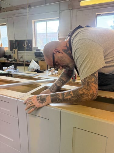 Master craftsman building custom cabinetry in a woodshop.