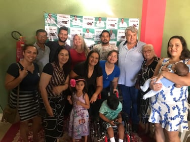 A diverse group of people posing for a community photo in front of a Dr. Lucas campaign banner.