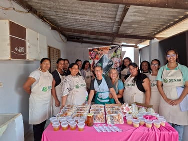 Group of women in SENAR aprons showcasing artisanal food products at a rural training workshop.