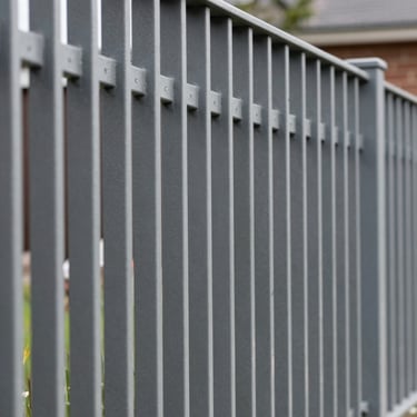 Architectural photography of a modern metal fence with clean vertical lines, emphasizing technical precision and quality paint finish in a Baltic garden.