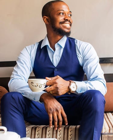 A man wearing a blue formal wear holding a cup of coffee