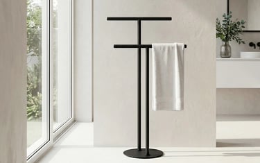 Freestanding matte black towel rack with a white towel in a modern minimalist bathroom.