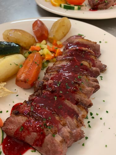 Magret de pato, salsa a la frambuesa, patatas castillo y verduras 